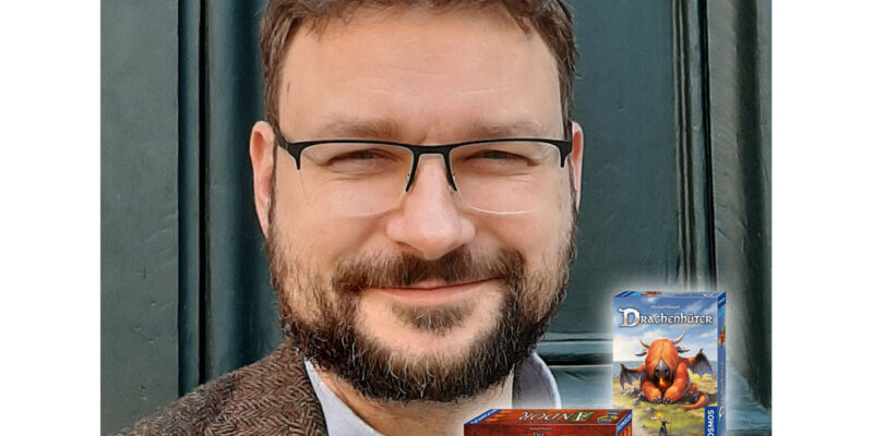 Mann mit Brille und drei Brettspiele